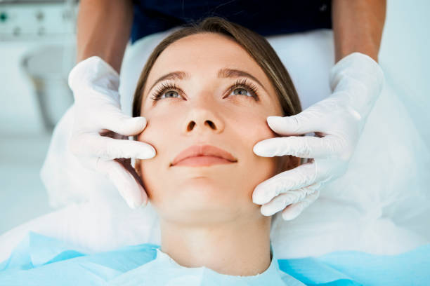 Dermatologist examining a female patient's skin in a clinic