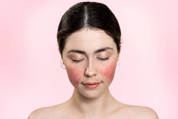 Portrait of a young woman with closed eyes showing natural makeup and healthy skin on a pink background