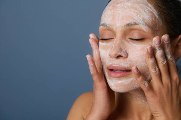 Woman applying facial mask skincare treatment