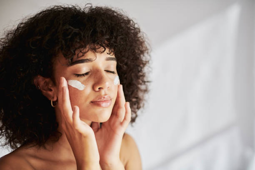 Woman applying facial moisturizer